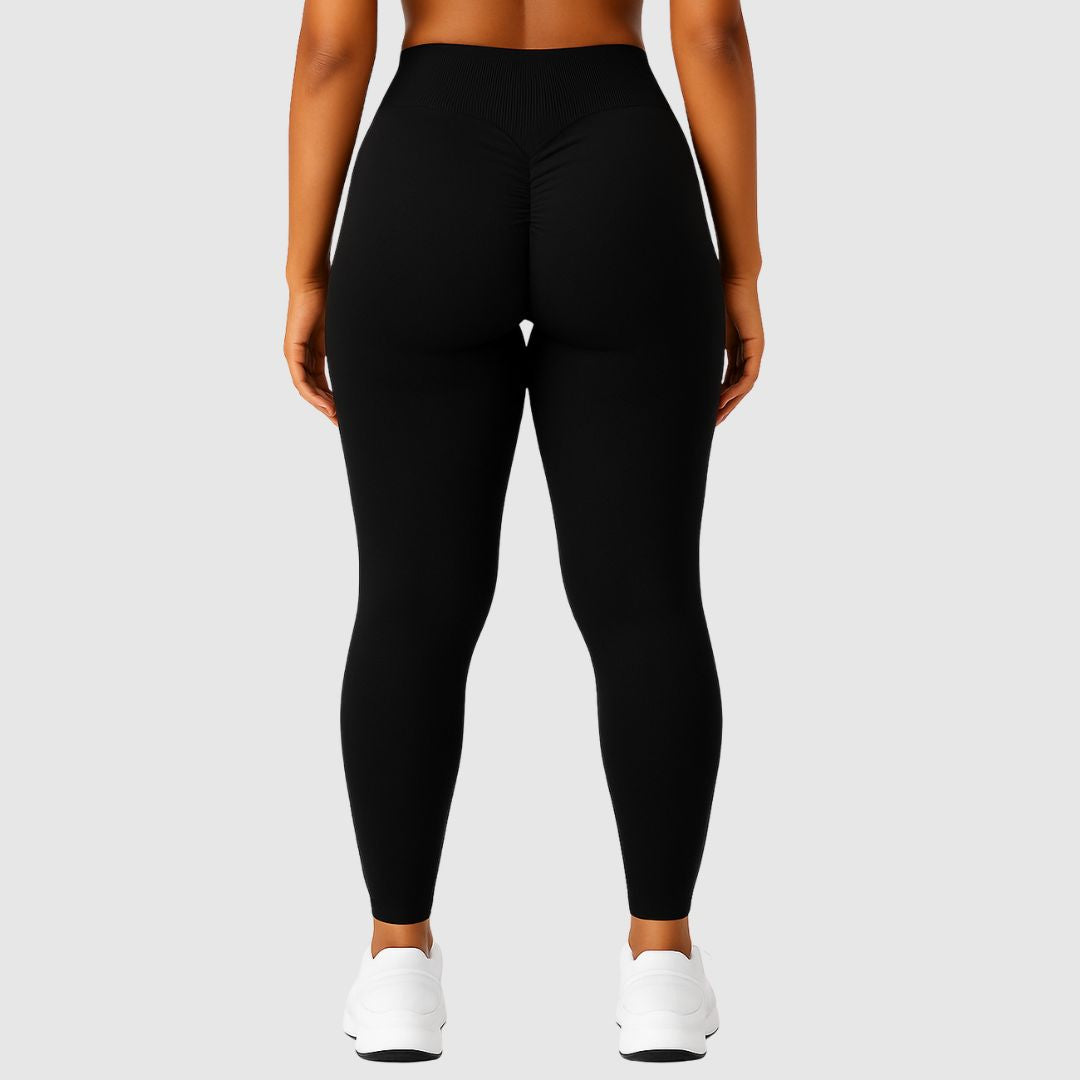 Rückansicht schwarzer High-Waist-Leggings mit scrunch-Naht – getragen von sportlicher Frau in weißem Sneaker.